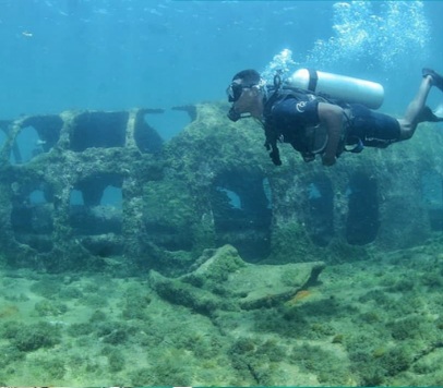 Mergulhador de cilindro observando o naufrágio submerso