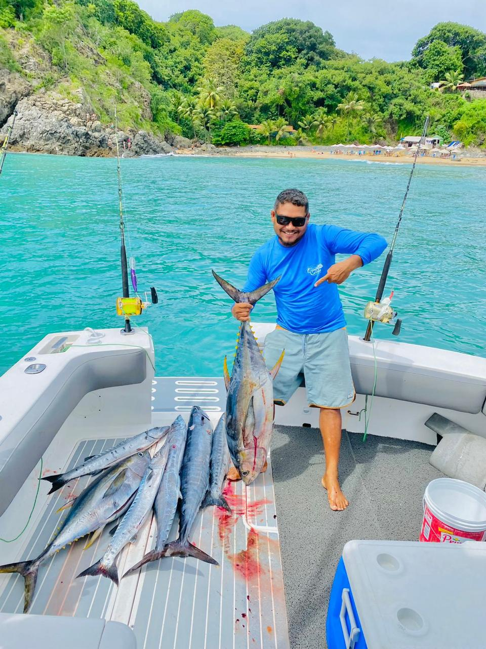 Pescador com um peixe capturado no passeio de pesca oceânica