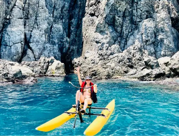 Viajante em bike aquática diante das formações rochosas de Fernando de Noronha